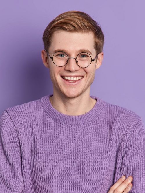 cheerful-handsome-man-keeps-arms-folded-looks-confidently-at-camera-wears-round-spectacles-and-long-e1627313404654.jpg